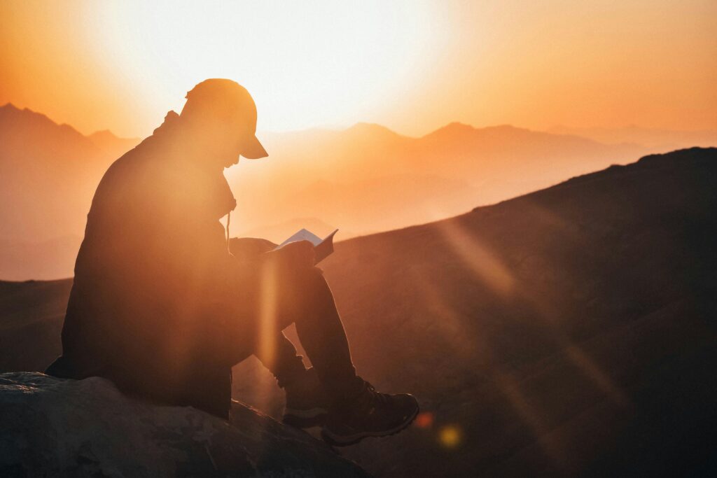 Solo traveler reading at sunrise in Colombian mountains, reflecting in solitude